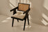 Black rattan dining chair with upholstered seat named Pierre, showcasing a stylish and comfortable design for modern dining spaces.