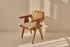 Brown rattan dining chair with upholstered seat, model Pierre, showcasing its woven rattan design and comfortable cushion.
