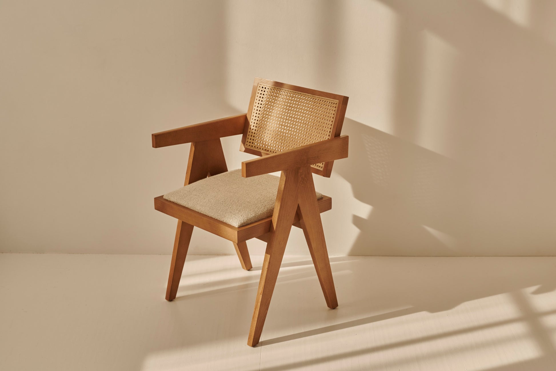 Brown rattan dining chair with upholstered seat, model Pierre, showcasing its woven rattan design and comfortable cushion.