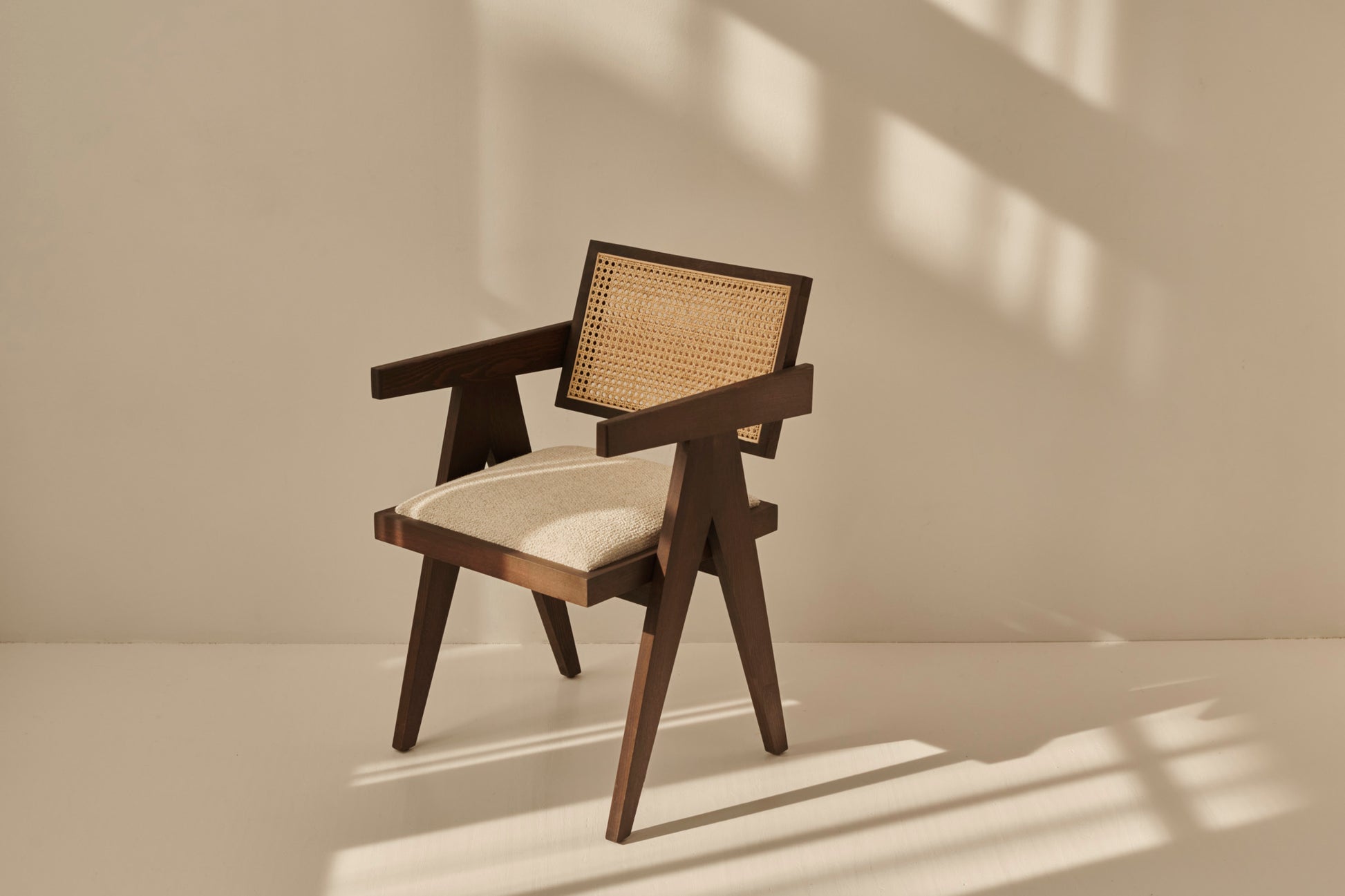 Dark brown rattan dining chair with upholstered seat, model Pierre, stylish and comfortable for modern dining rooms.