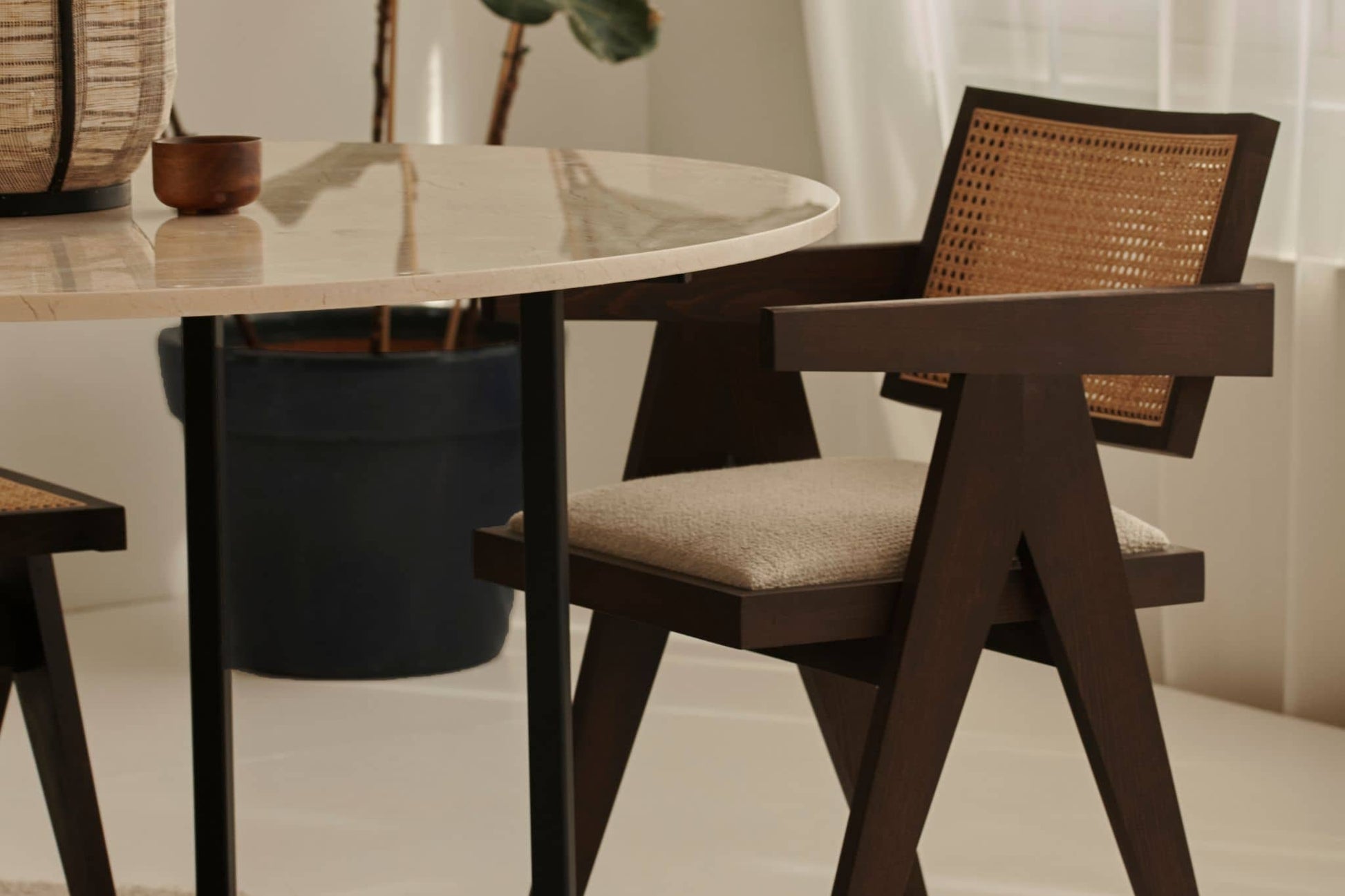 Dark brown rattan dining chair with upholstered seat, model Pierre, showcasing a stylish and comfortable design.