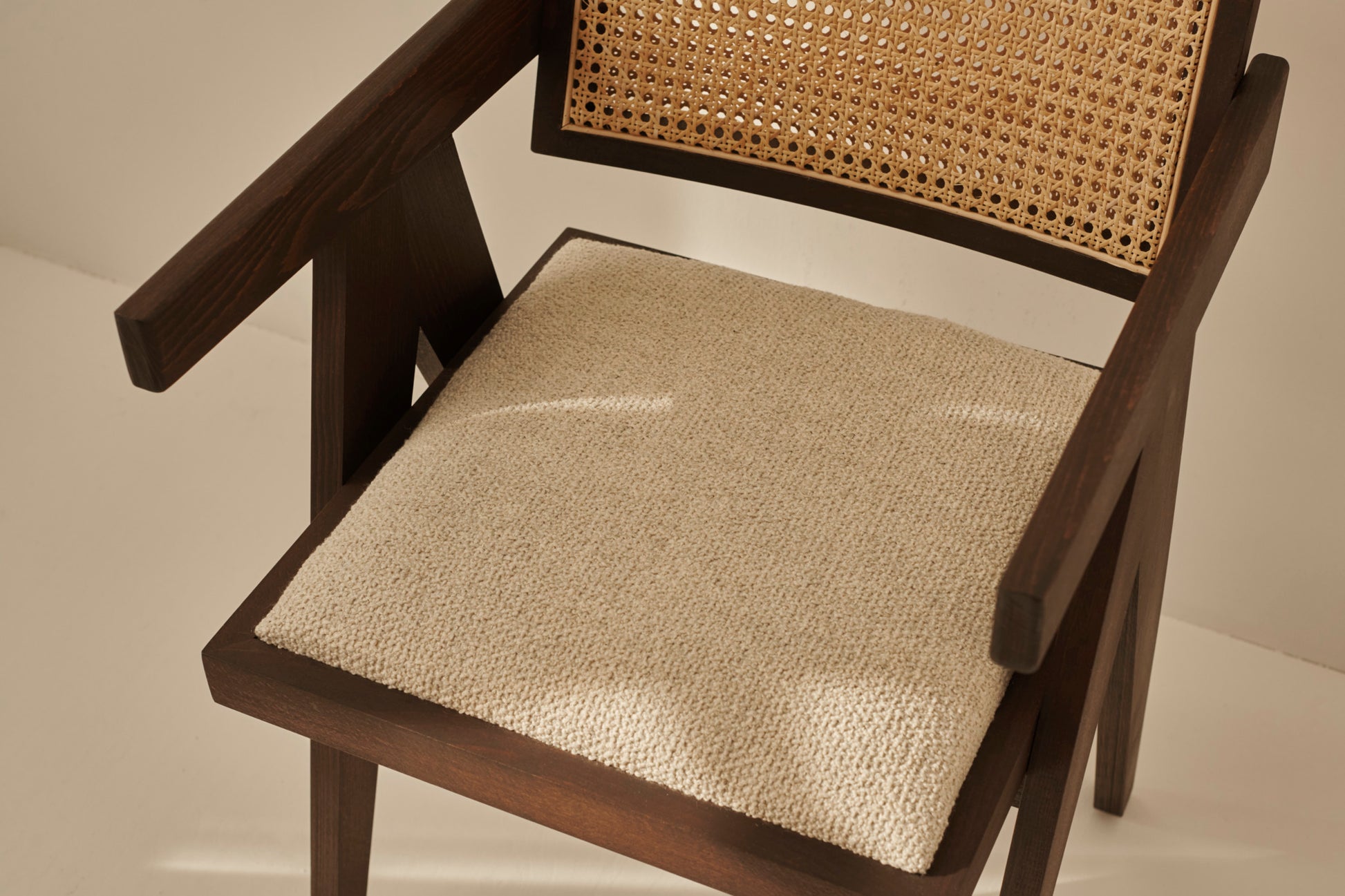 Dark brown rattan dining chair with upholstered seat, model Pierre, featuring a stylish and comfortable design.