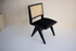 Black rattan dining chair with upholstered seat and no armrests, model Pierre, modern design for stylish dining spaces.