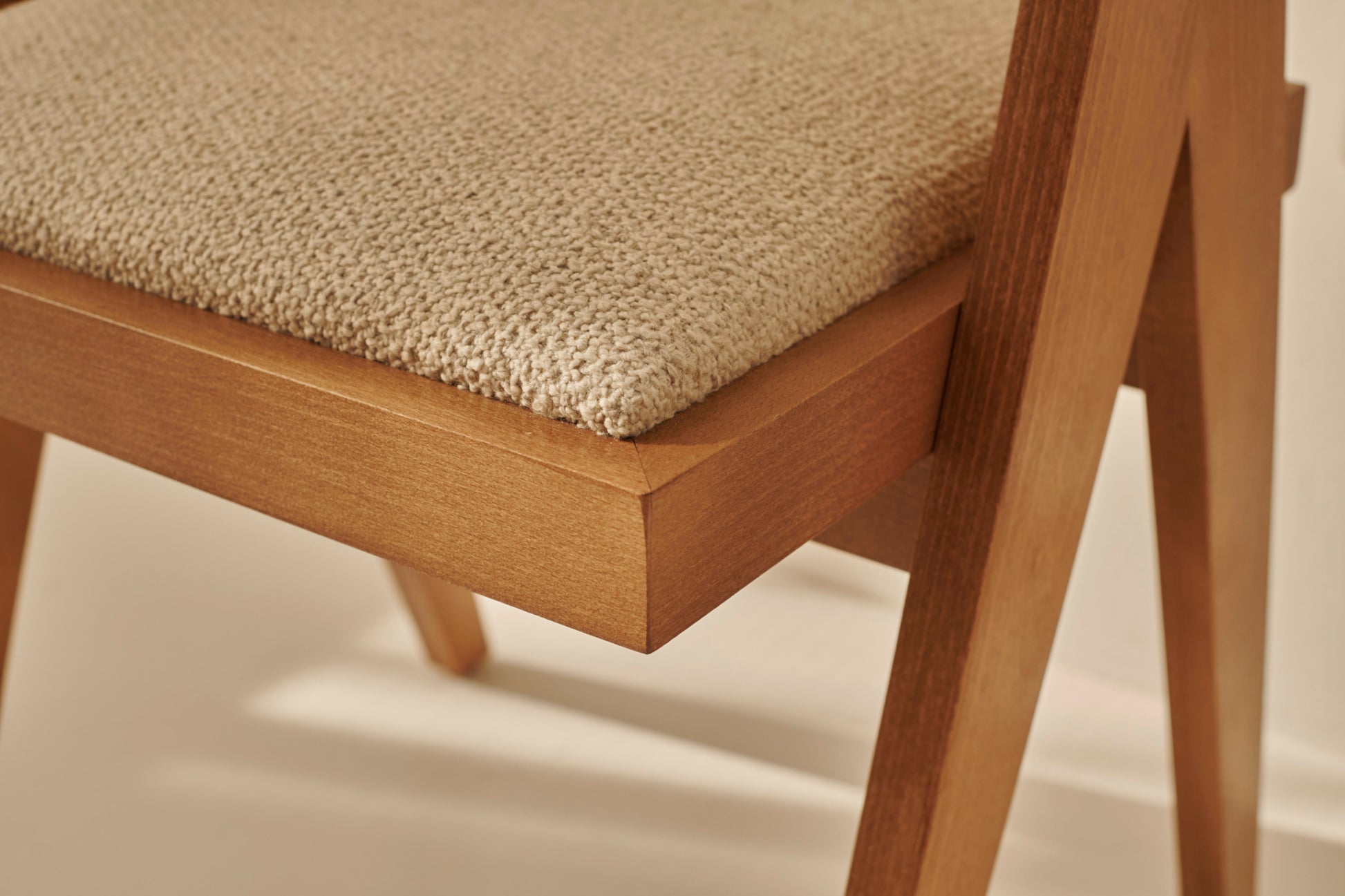Rattan dining chair with upholstered seat and no armrests in brown, designed by Pierre for stylish comfort.