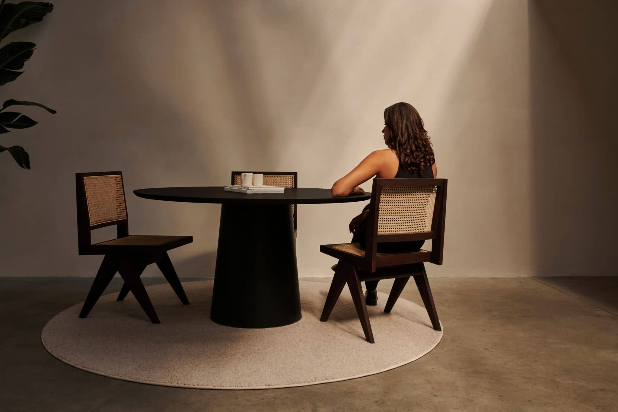 Black rattan dining chair without armrests, Pierre style, showcasing a sleek woven design and sturdy frame.