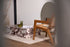 Brown rattan fauteuil named Pierre with a curved design, showcasing a stylish and comfortable seating piece.
