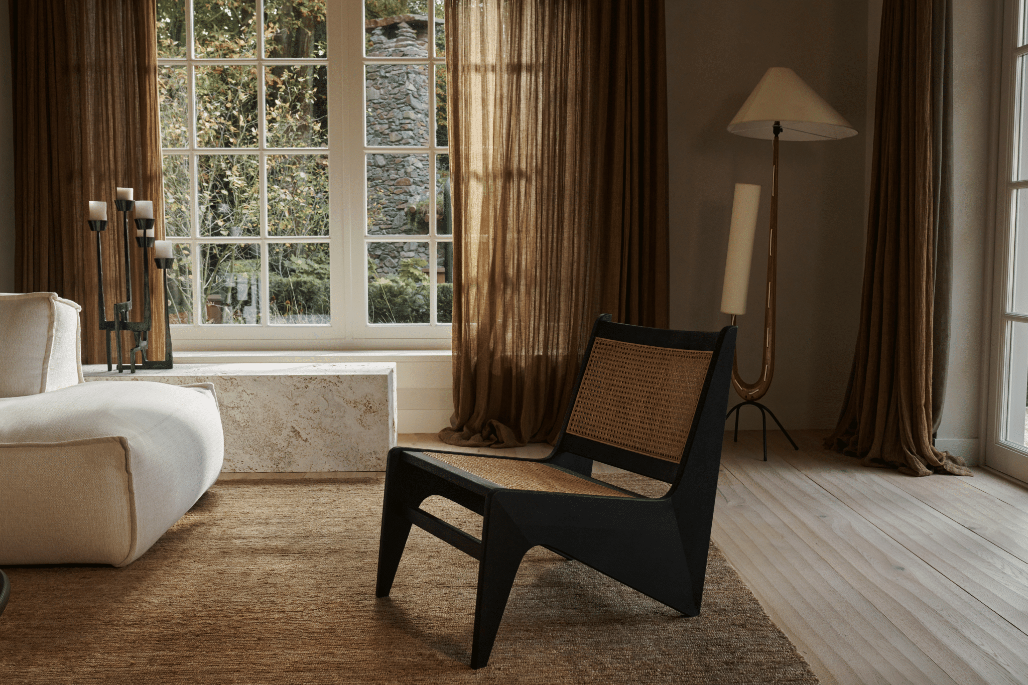 Dark brown Rattan Kangaroo Chair named Pierre with a cozy, rounded design and sturdy rattan construction.