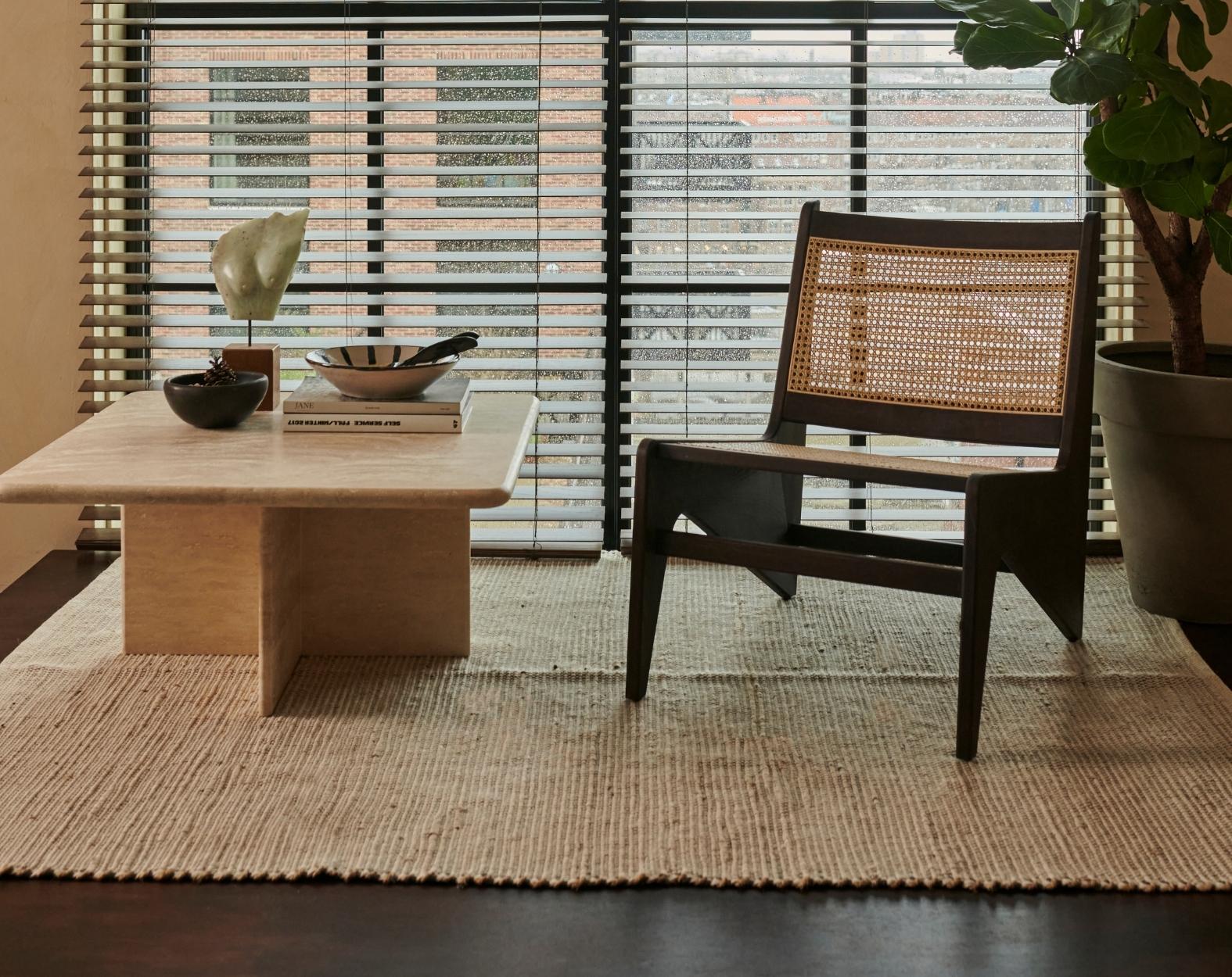 Dark brown rattan Kangaroo Chair named Pierre with a cozy, curved design perfect for stylish living spaces.