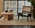 Dark brown rattan Kangaroo Chair named Pierre with a cozy, curved design perfect for stylish living spaces.
