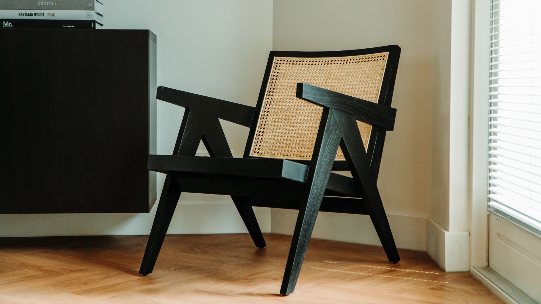 Black rattan lounge chair named Pierre with a modern design, perfect for stylish indoor or outdoor seating.