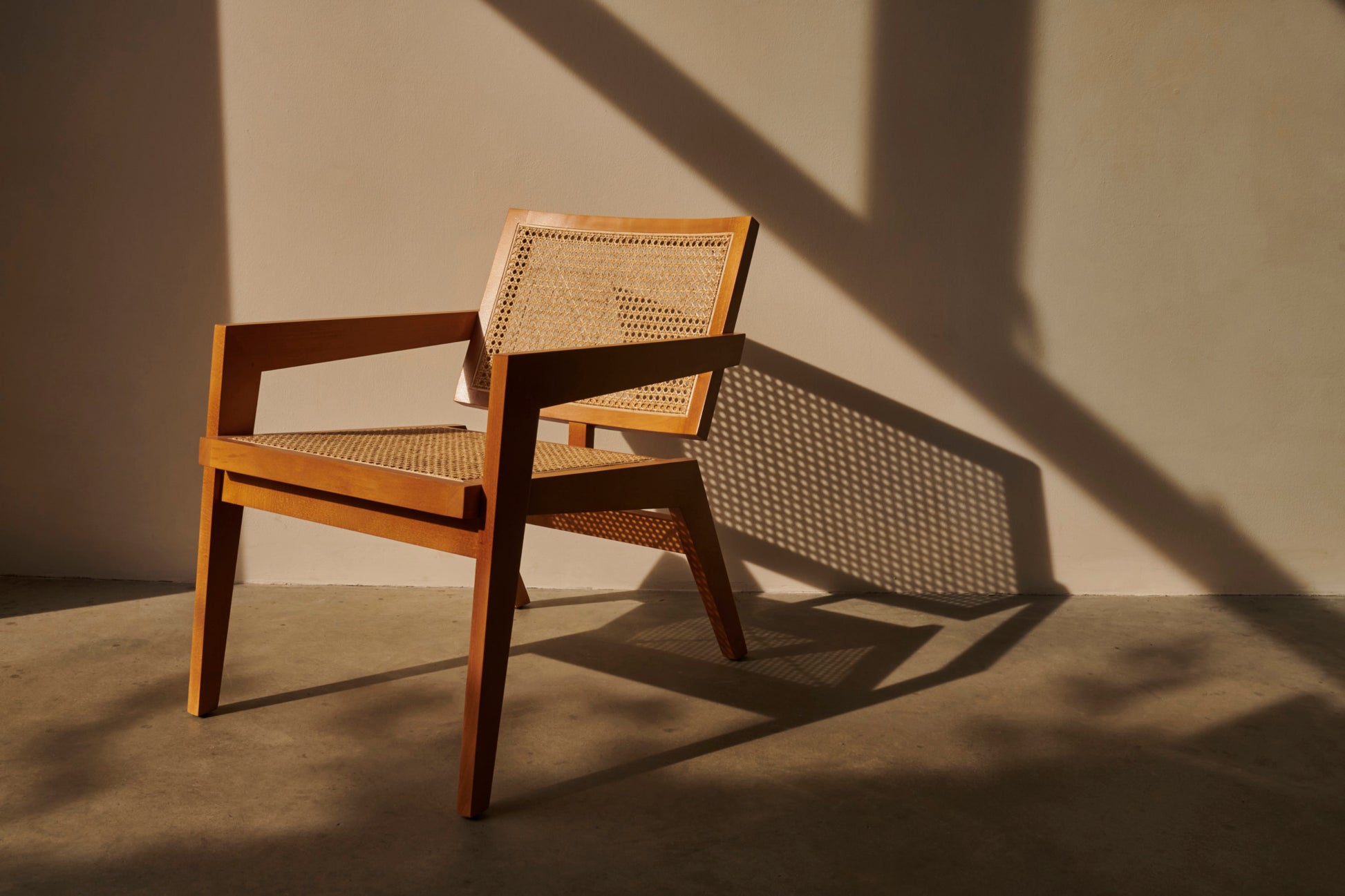Black rattan lounge chair named Pierre with a modern design, perfect for relaxing indoor or outdoor spaces.