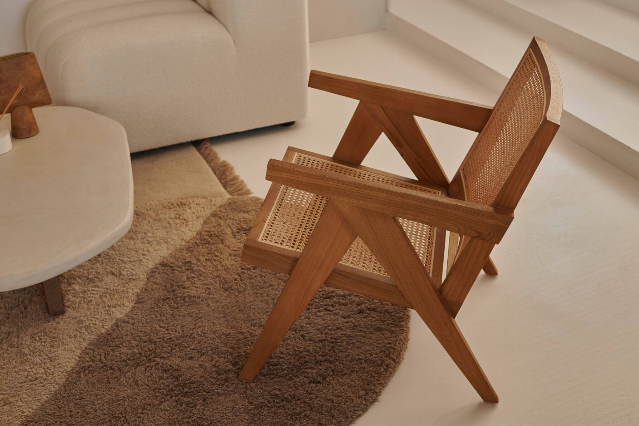 Brown rattan lounge chair named Pierre with a modern design, featuring a comfortable seat and sturdy frame.