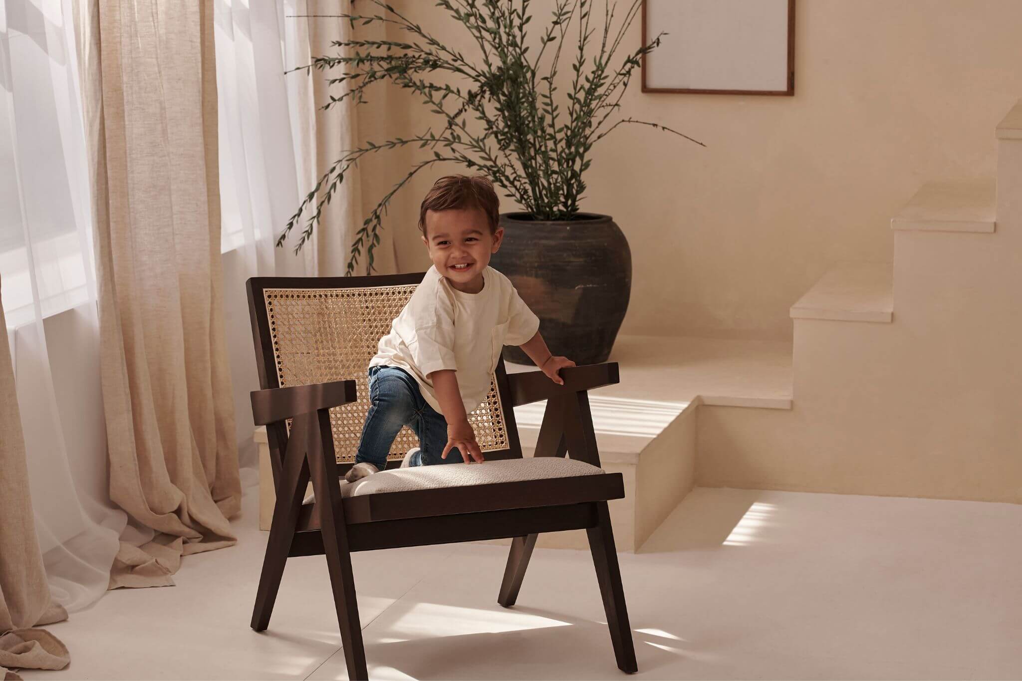 Dark brown rattan lounge chair with upholstered seat named Pierre, stylish and comfortable for outdoor or indoor use.