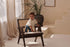 Dark brown rattan lounge chair with upholstered seat named Pierre, stylish and comfortable for outdoor or indoor use.