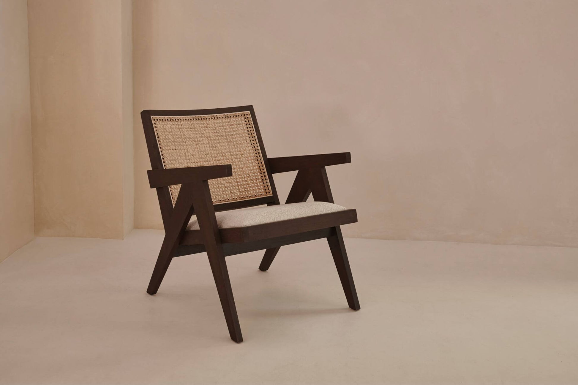 Dark brown rattan lounge chair with upholstered seat from Pierre collection, stylish and comfortable indoor or outdoor seating.