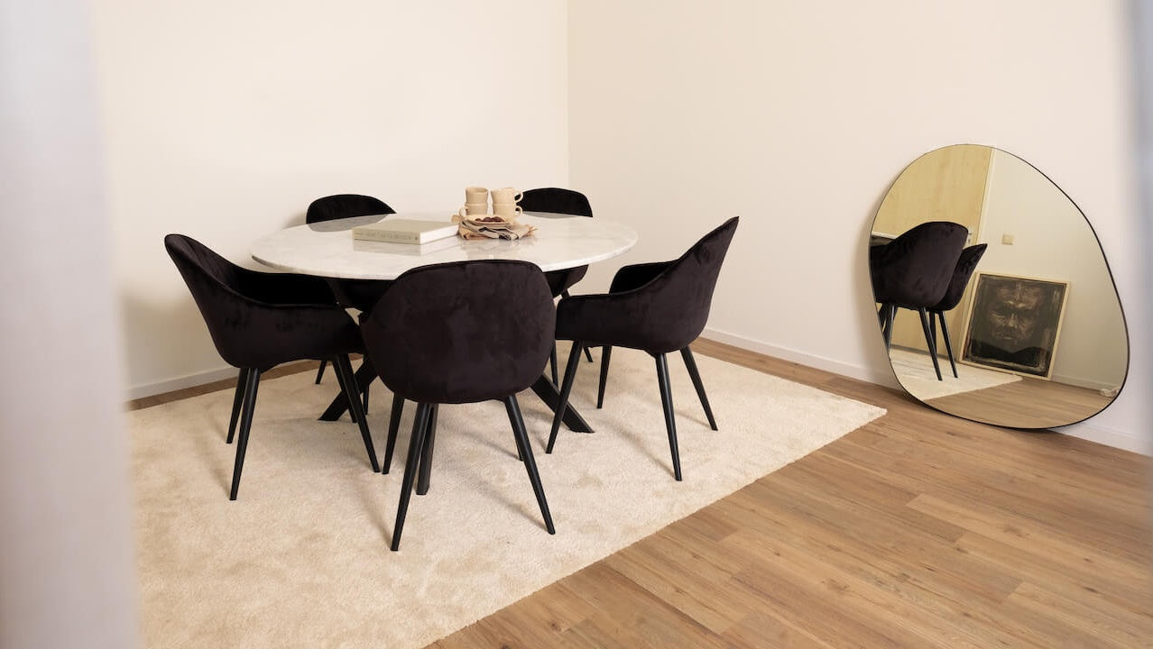 Round marble dining table with Bianco Carrara white surface and arch metal frame, modern and glossy design.