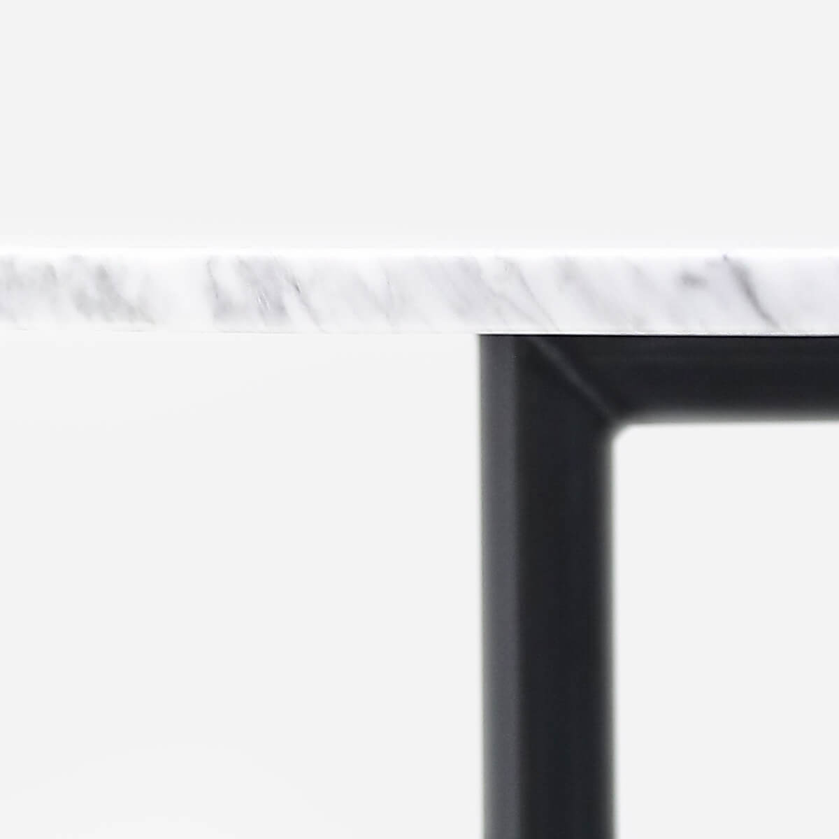 Glossy round marble dining table with white Bianco Carrara marble top and cross metal frame, modern and elegant design.
