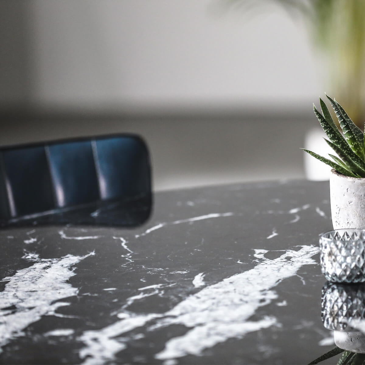 Round Nero Marquina black marble dining table with glossy finish and sleek arch metal frame, ideal for modern dining rooms.