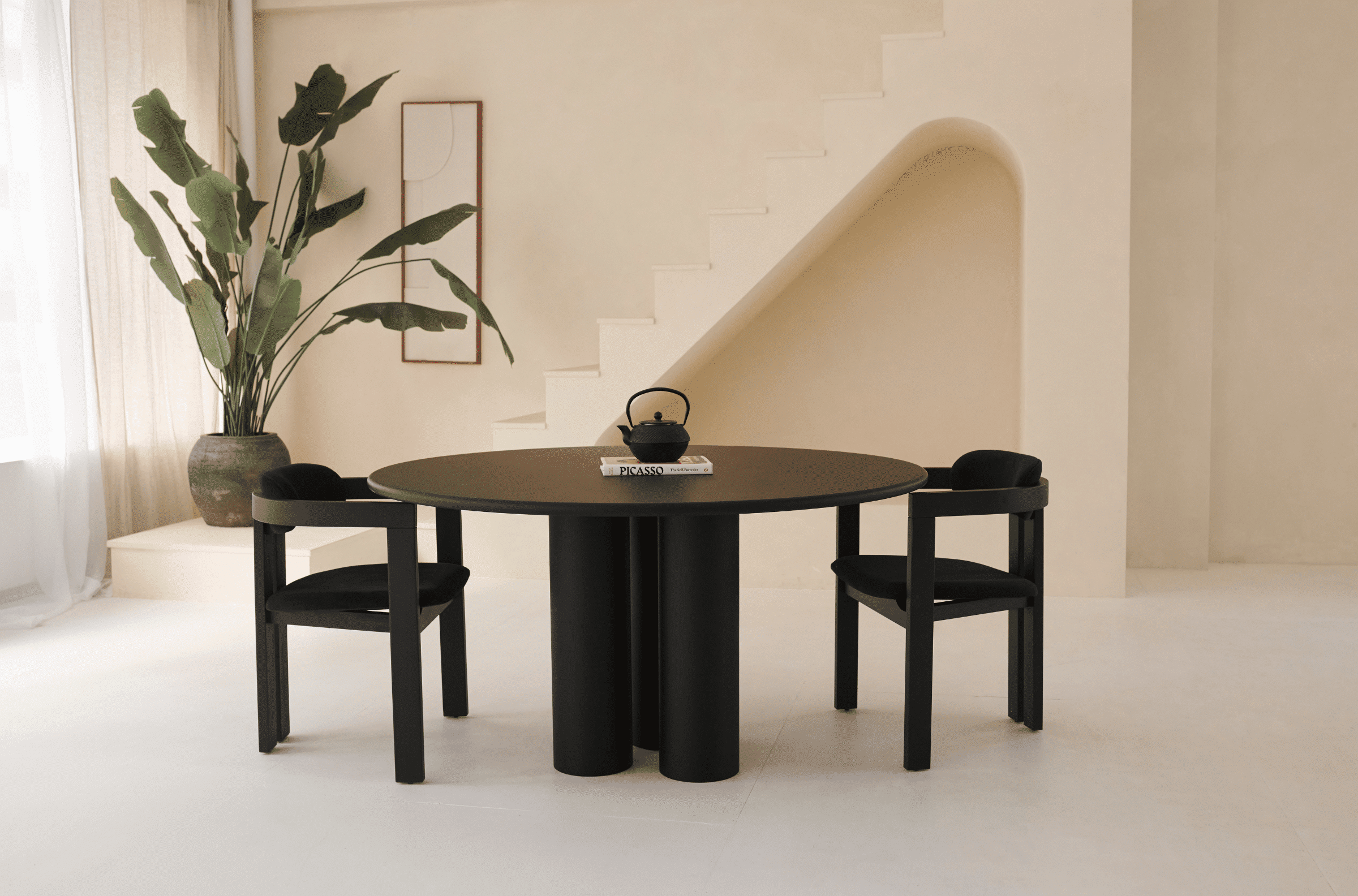 Black oak round dining table named FRANKY with a sleek design, featuring a sturdy base and smooth tabletop surface.