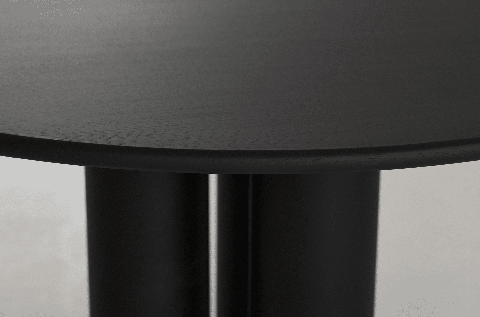 Round dining table with black oak finish, FRANKY by My Store, showcasing smooth surface and sturdy wooden legs.