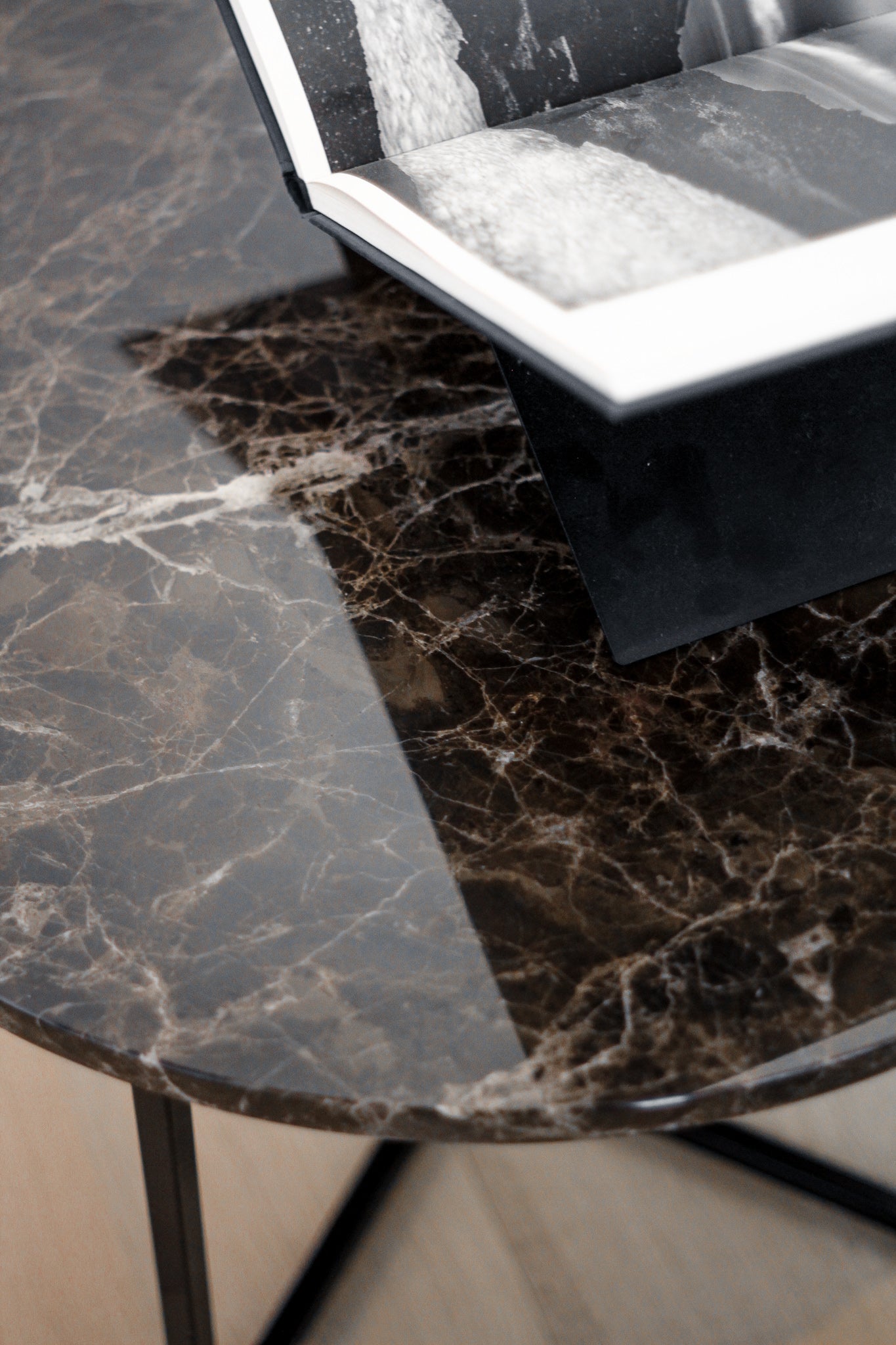 Dark Emperador brown round marble coffee table with glossy finish, showing its smooth surface and sturdy base.