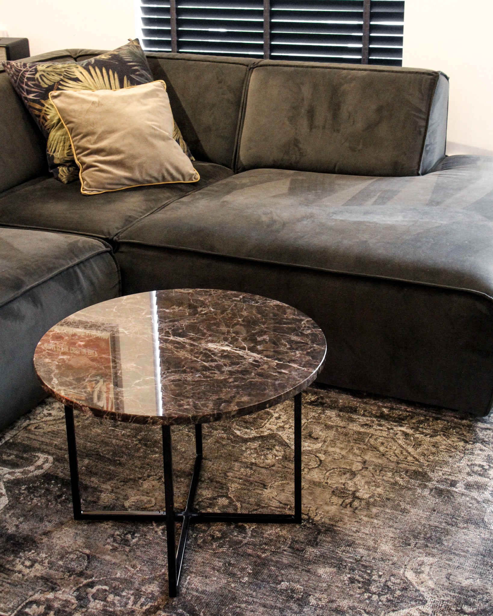 Dark Emperador brown round marble coffee table with glossy finish, smooth surface, and sturdy base.