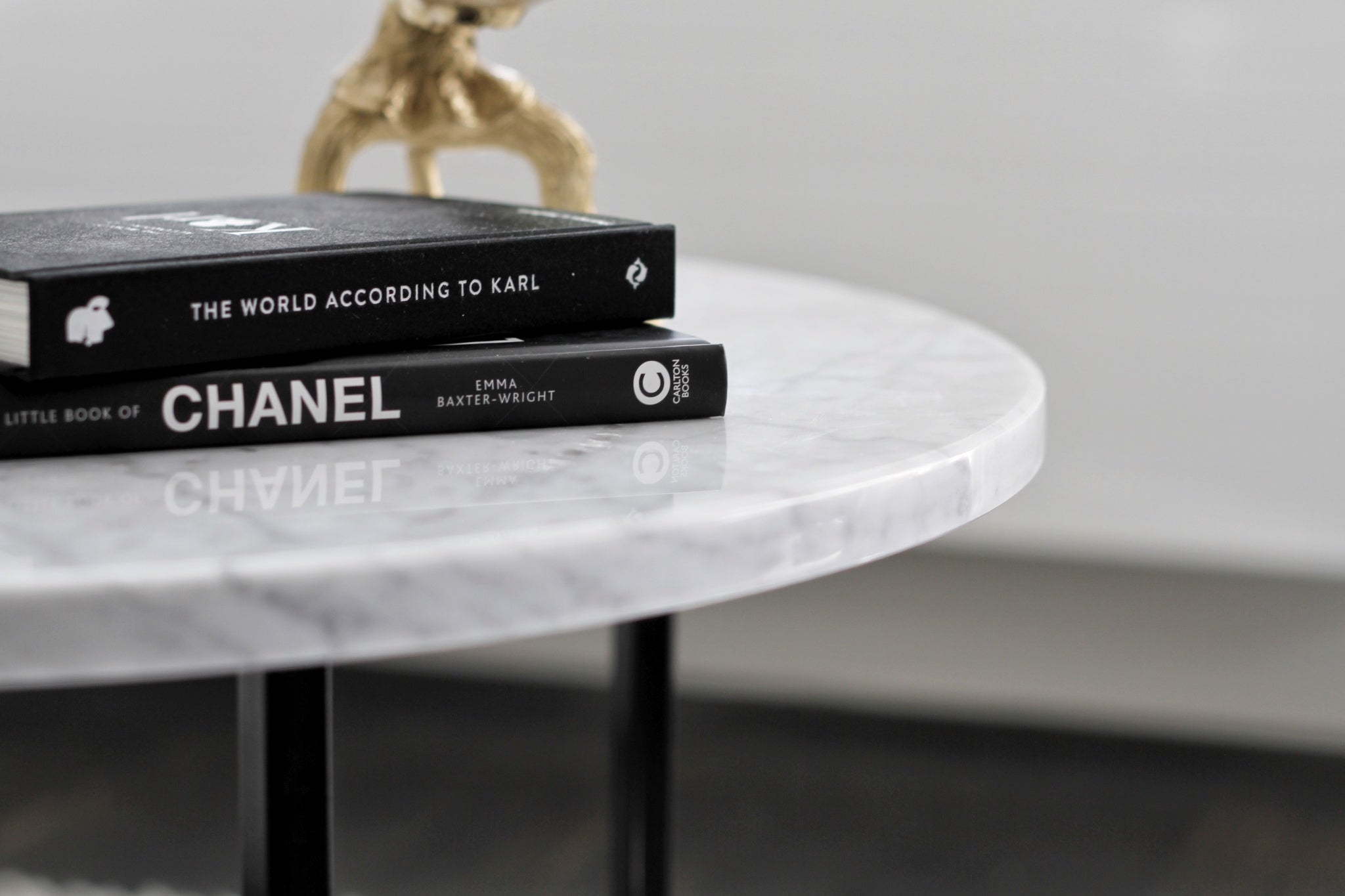 Round marble coffee table with Bianco Carrara white surface and light brown spots, featuring a matte finish and subtle scratches.