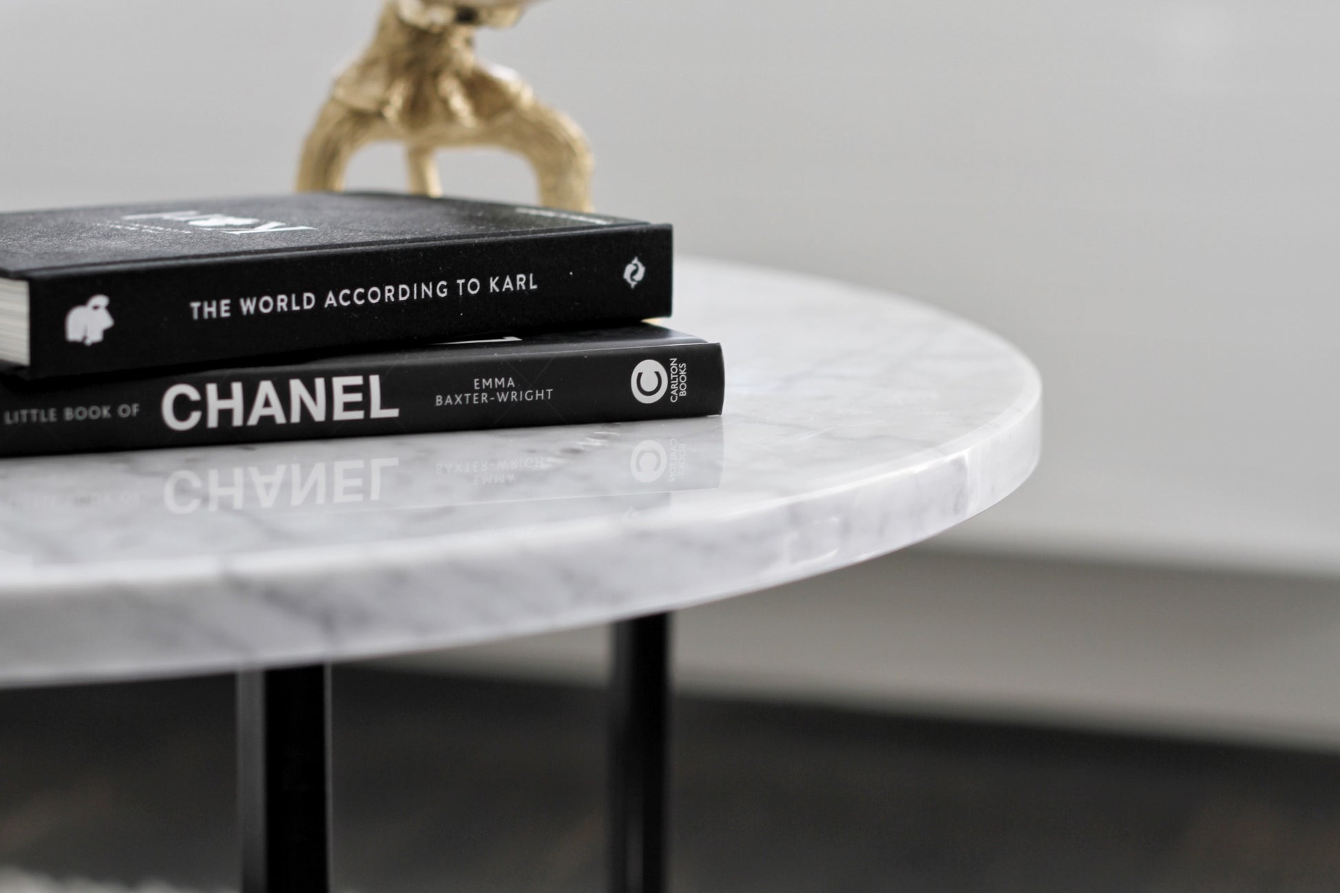 Round marble coffee table with Bianco Carrara white surface and light brown spots, featuring a matte finish and subtle scratches.