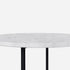 Round marble coffee table with Bianco Carrara white surface, matte finish, light brown spots, and subtle scratches.