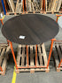 Flow round dining table in charcoal oak finish with a 140cm diameter, showcasing edge damage and small scratches.