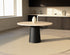 Flow round dining table with ash white oak surface and black cylindrical base, modern and stylish for dining rooms.