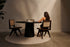 Flow round dining table with smoked oak tabletop and black cylindrical base, modern design for contemporary dining spaces.