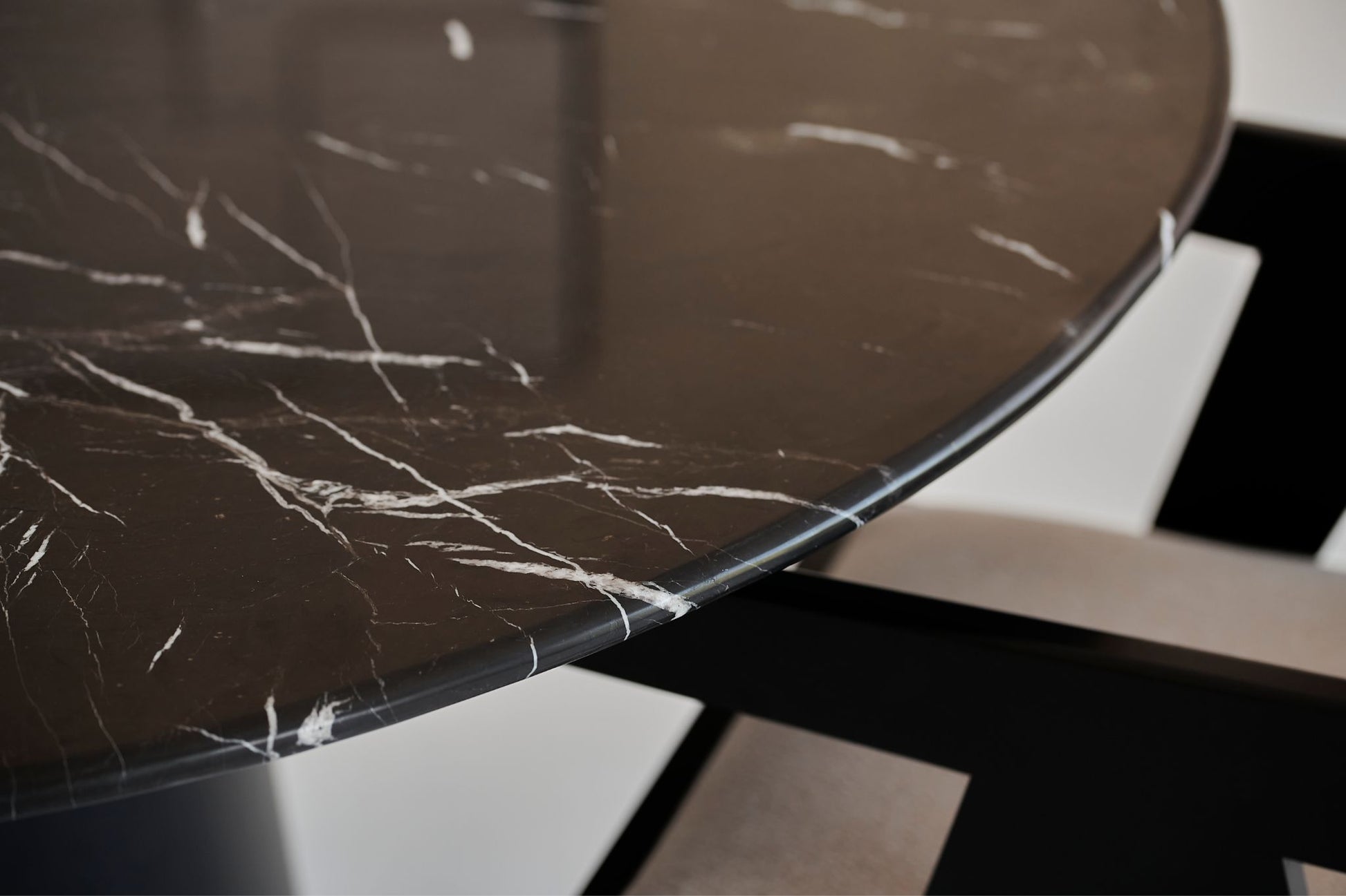 Flow round dining table with Nero Marquina black marble top and black cylindrical base, 110 cm diameter, matte finish.