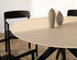 Round oak dining table with ash white finish and arched frame, showcasing a sleek, modern design for contemporary dining spaces.