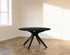Round oak dining table with charcoal finish and arched frame, showcasing a sturdy and stylish design for modern dining rooms.