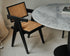 Natural oak round dining table with center leg, perfect for modern dining spaces, showcasing smooth wood grain and sturdy design.