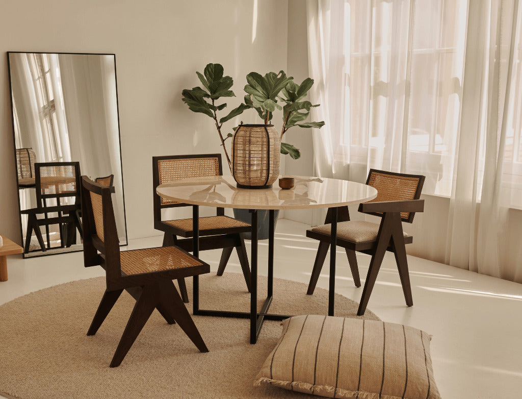 Natural round oak dining table with cross frame design, showcasing smooth wood surface and sturdy construction.