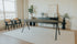 Oval oak dining table with charcoal finish and V-frame design, showcasing a sleek and modern dining surface.