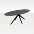 Oval oak dining table with charcoal finish and arched frame, showcasing a sleek and modern design for stylish dining spaces.