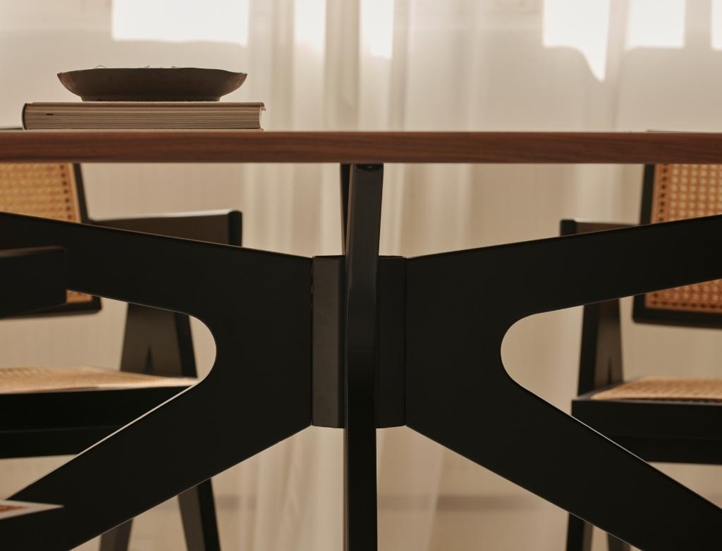 Smoked oval oak dining table with arched frame, showcasing a sleek, modern design perfect for contemporary dining rooms.