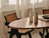 Oval walnut dining table with arched frame, showcasing smooth wood finish and modern design for elegant dining spaces.