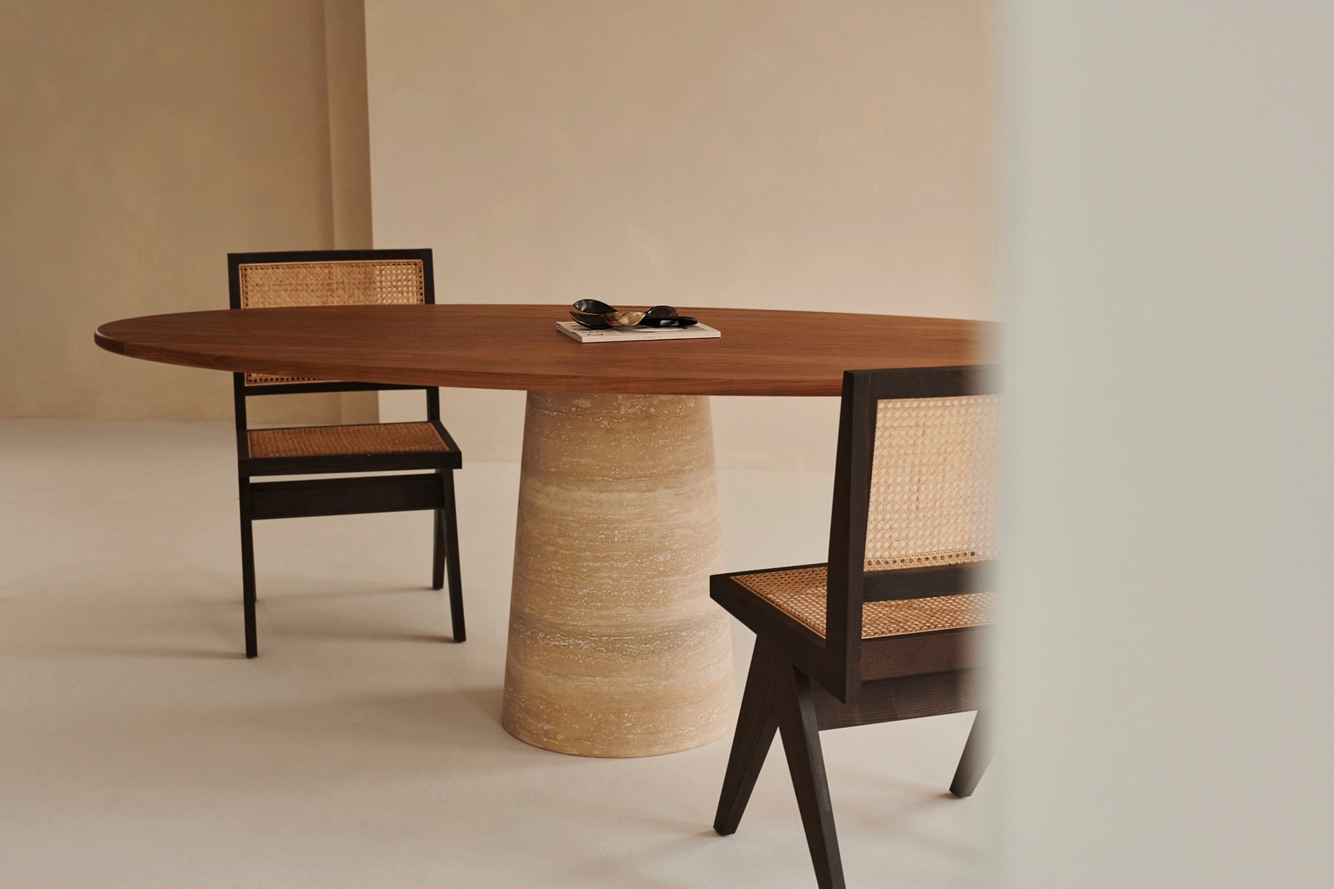 Oval walnut FLOW dining table with travertine cylinder base, 180x90 cm, modern and elegant design.
