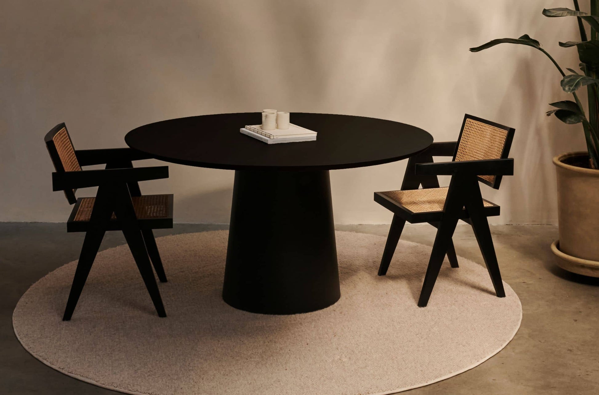 Flow round dining table with Amarante violet marble top and black cylindrical base, modern and stylish for contemporary dining spaces.