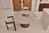 Round dining table with Crema Altea marble top and black cylinder base, sleek and modern design by My Store.